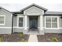 Inviting entryway with stately columns, fresh landscaping, and a stylish black front door at 1780 Nature Cove Ln, Clermont, FL 34711