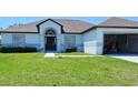 Charming one-story home featuring a gray roof, attached garage, and well-maintained front yard at 1930 Dolphin Drive, Kissimmee, FL 34759