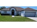 Charming one-story home featuring a gray roof, attached garage, and well-maintained front yard at 1930 Dolphin Drive, Kissimmee, FL 34759