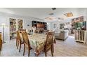 Open-concept living room and dining area with wood-look tile flooring and brick fireplace at 220 Morton Ln, Winter Springs, FL 32708