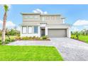 Contemporary two-story home with a manicured lawn and paved driveway leading to a two-car garage at 2496 Rama Dr, Kissimmee, FL 34746