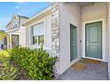 Close-up of the home's entrance with a stylish door, stone accents, and manicured shrubs at 3123 Camden Way, Davenport, FL 33837