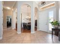 Grand foyer with arched doorways, tile floors, and view to dining room at 3753 Heirloom Rose Pl, Oviedo, FL 32766
