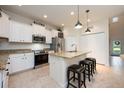 Well-lit kitchen featuring granite countertops, stainless appliances, and counter seating at 411 Evening Sky Dr, Oviedo, FL 32765
