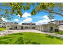 Modern white house with a wide driveway and lush green lawn beneath a bright, partly cloudy sky at 49 Interlaken Rd, Orlando, FL 32804