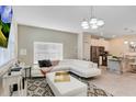 Spacious living room with white sectional, open concept kitchen and stylish decor making it perfect for modern living at 4984 Windermere Ave, Kissimmee, FL 34746