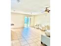 Bright living room featuring neutral decor, tile flooring, and sliding glass doors leading to the outdoors at 535 Aeolian Dr, New Smyrna Beach, FL 32168