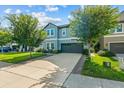 Charming two-story home with a well-manicured lawn and a two-car garage is bathed in natural light against a blue sky at 672 Seven Oaks Blvd, Winter Springs, FL 32708