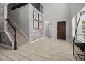 The bright foyer features tile flooring, a staircase with wrought iron spindles, and decorative artwork at 672 Seven Oaks Blvd, Winter Springs, FL 32708