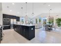 Modern, open-concept kitchen with stainless steel appliances, center island and eat in space, seamlessly connected to the living area at 744 Curly Locks Loop, Apopka, FL 32703