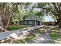 This single-story home has a well-manicured front lawn and a long driveway, providing ample parking at 845 Edgewater Cir, Eustis, FL 32726
