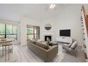 Bright living room with large windows, a fireplace, a ceiling fan, and modern decor at 940 Douglas Ave # 132, Altamonte Springs, FL 32714