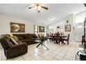 Bright living room with tiled floors and comfortable brown sofa. Open floorplan leads to the dining area at 9814 Piney Point Cir, Orlando, FL 32825
