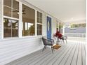Welcoming front porch with a colorful door, comfortable chairs, and picturesque surroundings at 1031 Morningside Dr, Eustis, FL 32726
