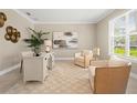 Inviting home office featuring neutral tones, ample natural light, and comfortable seating at 13618 Heaney Ave, Orlando, FL 32827