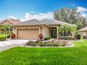 Beautiful single-story home with a manicured lawn, mature landscaping, and a welcoming facade at 16631 Champions Ct, Clermont, FL 34711