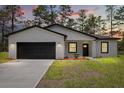 Well-kept one-story home with a dark-colored garage door, complemented by a lush front lawn at 17485 Sw 41St Cir, Ocala, FL 34473