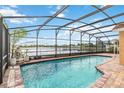 Inviting screened-in pool area with a view of the serene lake beyond at 344 Blue Bayou Dr, Kissimmee, FL 34743