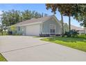 View of house showing long driveway, two car garage, well manicured lawn and view of back yard at 36646 Oconee Ave, Eustis, FL 32736