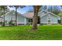 Charming one-story home featuring a lush green lawn and inviting curb appeal with stone accents and mature trees at 36646 Oconee Ave, Eustis, FL 32736