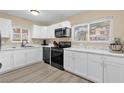 Bright kitchen featuring white cabinetry, marble countertops, and modern black appliances at 4102 Plantation Cove Dr # 201, Orlando, FL 32810