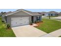 Inviting single-story home with an attached two-car garage and manicured front lawn at 489 Panaro Ln, Haines City, FL 33844