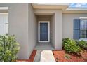 Covered entryway with stylish front door and neat landscaping, creating a warm welcome at 489 Panaro Ln, Haines City, FL 33844