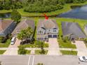 Aerial view of a home with well-kept landscaping backing onto a serene pond, offering privacy at 5161 Dove Tree St, Orlando, FL 32811