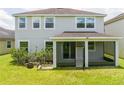 Backyard view of a house with a screened-in porch and a well-maintained lawn at 5161 Dove Tree St, Orlando, FL 32811
