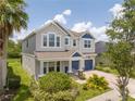 Stylish two-story home showcasing a manicured lawn and blue accents on the facade and two-car garage at 5161 Dove Tree St, Orlando, FL 32811