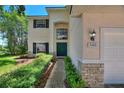 Attractive home with a beautiful lawn, colorful shrubbery, and a stately front door and entryway at 546 Windsor Pl, Davenport, FL 33896
