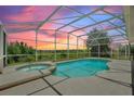 Screened-in pool with spa and sunset views at 546 Windsor Pl, Davenport, FL 33896