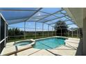 Inviting screened-in pool with spa and view of greenery at 546 Windsor Pl, Davenport, FL 33896