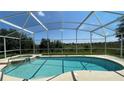 Inviting screened-in pool with spa and view of greenery at 546 Windsor Pl, Davenport, FL 33896