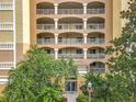 Close-up of condominium entrance featuring balconies and a beautifully landscaped entryway at 6336 Buford St # 207, Orlando, FL 32835
