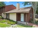 Charming townhome with a front door, brown and beige siding, chimney, and green lawn at 6809 Magnolia Pointe Cir, Orlando, FL 32810