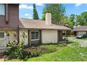 Charming townhome showcasing a front door, beige exterior, chimney, and well-maintained lawn at 6809 Magnolia Pointe Cir, Orlando, FL 32810