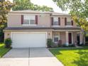 Charming two-story home featuring a spacious two-car garage, front porch, red shutters and manicured lawn at 8330 Lainie Ln, Orlando, FL 32818