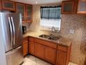 Well-lit kitchen with stainless steel refrigerator, and granite counters and backsplash at 1000 S Semoran Blvd # 415, Winter Park, FL 32792
