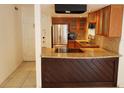 Charming kitchen with a breakfast bar, wooden cabinets, and stainless steel appliances at 1000 S Semoran Blvd # 415, Winter Park, FL 32792