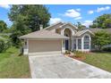 Inviting home showcasing well-maintained lawn, two-car garage, and a welcoming front entrance at 1021 Piedmont Oaks Dr, Apopka, FL 32703