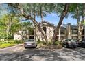 A condo complex with mature trees and lush landscaping, with cars parked in front of the building at 1055 Kensington Park Dr # 203, Altamonte Springs, FL 32714