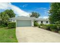 Single-story home featuring a two-car garage, white brick, a gray roof, and lush landscaping at 111 Woodstream Ct Ct, Maitland, FL 32751