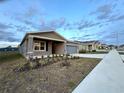 Single-story home featuring a neutral exterior, landscaping, and an attached garage at 1147 Pomelo St, Davenport, FL 33837