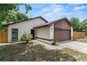 Single-Gathering home featuring stone accents, a two-car garage, and a manicured front yard at 1353 Ortega St, Winter Springs, FL 32708
