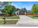 Well-maintained single-Gathering home featuring stone accents, a two-car garage, and a well-manicured lawn at 1353 Ortega St, Winter Springs, FL 32708