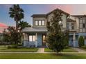 Attractive two-story house with a well-maintained lawn, a palm tree, and a welcoming front porch at 13755 Benavente Ave, Orlando, FL 32827