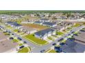 Wide aerial view of a neighborhood showcasing modern townhouses with attached garages and community layout at 1471 Mirabella Cir, Davenport, FL 33897