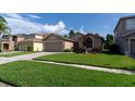 Charming single-story home featuring a well-manicured lawn and a two-car garage at 14831 Yorkshire Run Dr, Orlando, FL 32828