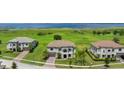 Aerial view of community homes with lush greenery and a water view in the distance at 1551 Gateway Ln, Kissimmee, FL 34746